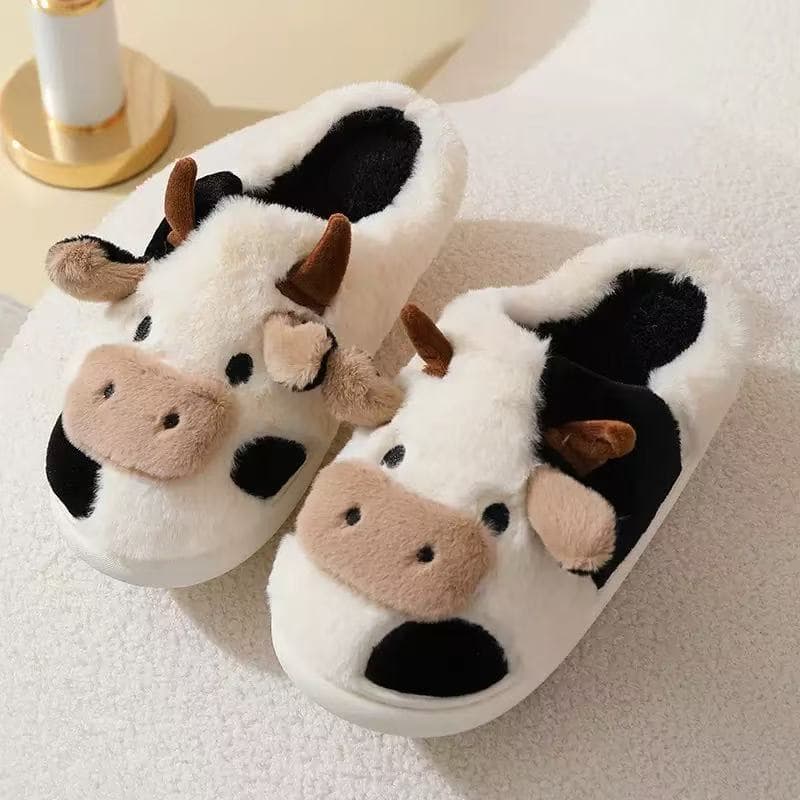 Par de pantufas brancas de vaquinha com manchas pretas